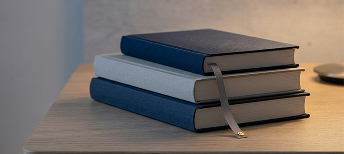 Gestapelte Fachbücher mit Lesezeichen auf einem Schreibtisch